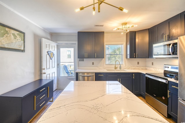 kitchen with visible vents, wood finished floors, light stone countertops, stainless steel appliances, and a sink