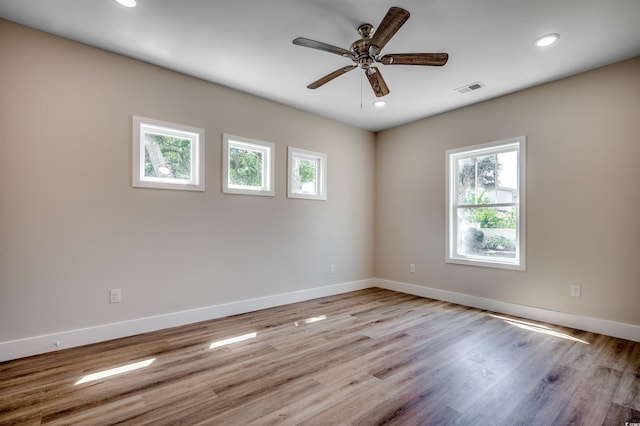 empty room with a ceiling fan, baseboards, visible vents, and plenty of natural light