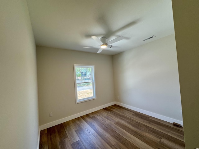 empty room featuring baseboards, a ceiling fan, dark wood finished floors, and visible vents