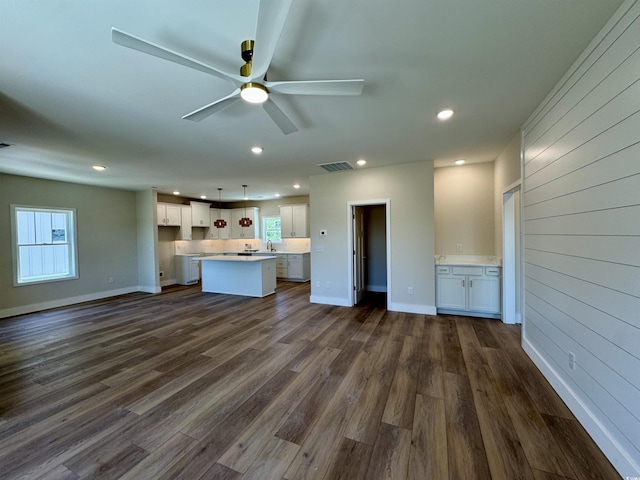 unfurnished living room with ceiling fan, dark wood finished floors, recessed lighting, baseboards, and visible vents