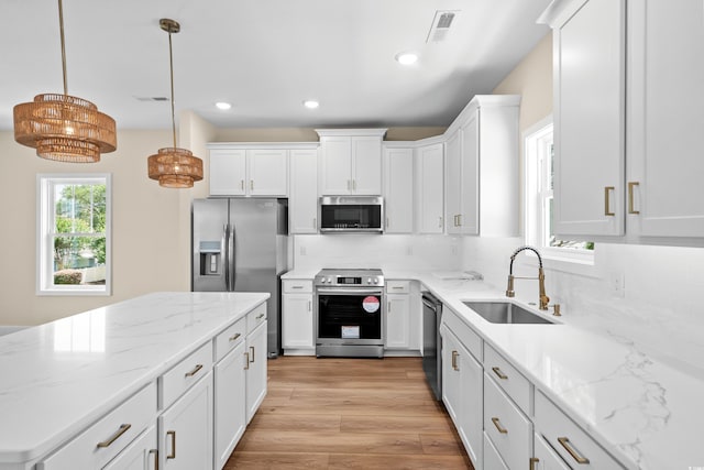 713 9th Ave S, North Myrtle Beach, SC 29582 - kitchen with appliances with stainless steel finishes, white cabinetry, backsplash, light wood-style floors, and recessed lighting