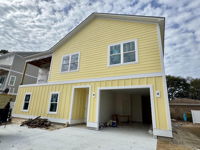 view of front facade with an attached garage, board and batten siding, and concrete driveway