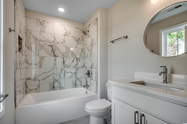 full bathroom featuring tiled shower / bath combo, vanity, and toilet