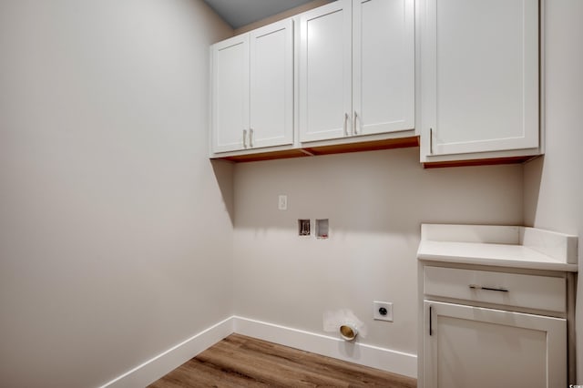 washroom with hookup for a washing machine, light wood-type flooring, hookup for an electric dryer, and cabinets