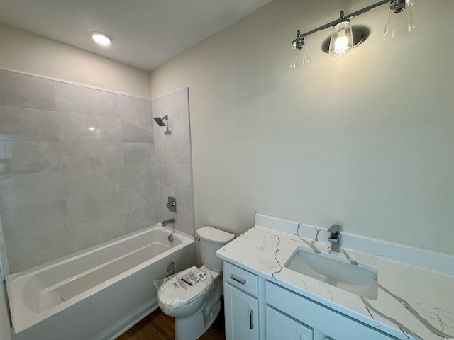 bathroom featuring vanity, toilet,  shower combination, and wood finished floors
