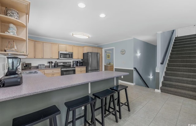 kitchen featuring stainless steel appliances, a kitchen breakfast bar, light brown cabinets, and kitchen peninsula