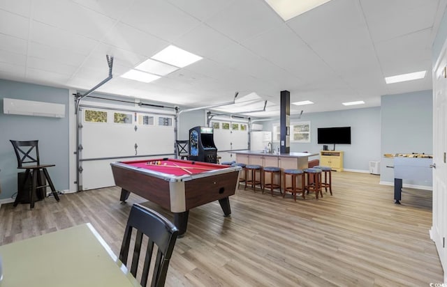 game room featuring a wall unit AC, pool table, indoor wet bar, and light wood-type flooring