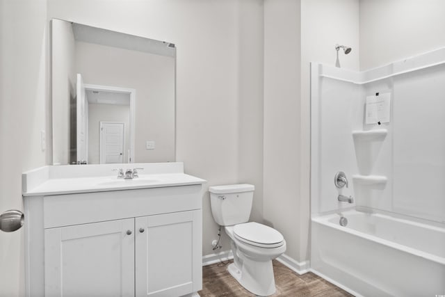 full bathroom with shower / bathtub combination, toilet, wood finished floors, vanity, and baseboards