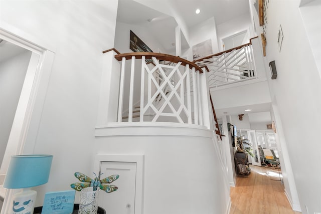 interior space with a towering ceiling and wood finished floors