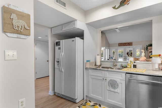 kitchen with white refrigerator with ice dispenser, light countertops, visible vents, a sink, and dishwasher