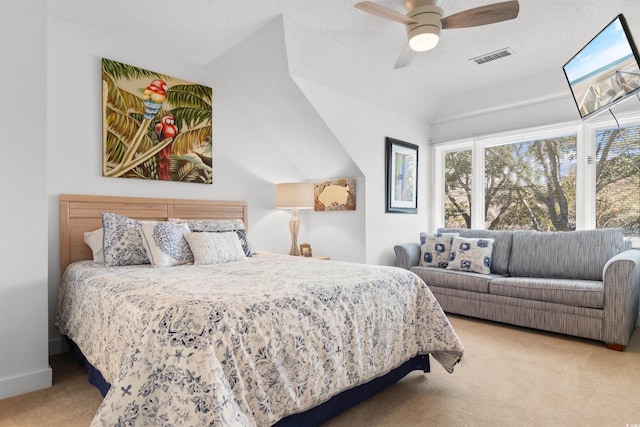 carpeted bedroom featuring a textured ceiling, baseboards, visible vents, and a ceiling fan