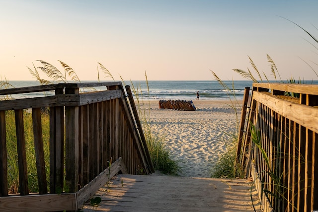 exterior space featuring a water view and a beach view