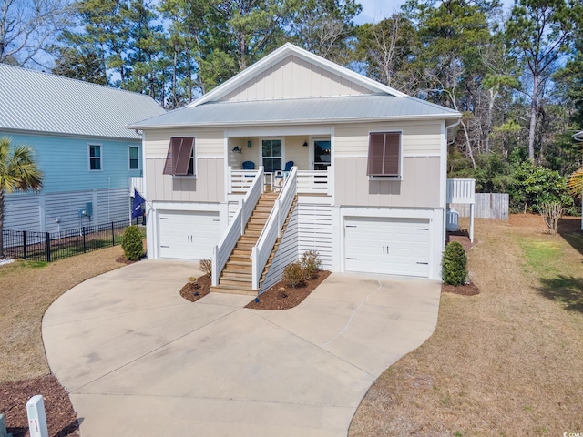 coastal home featuring stairs, a porch, an attached garage, and fence