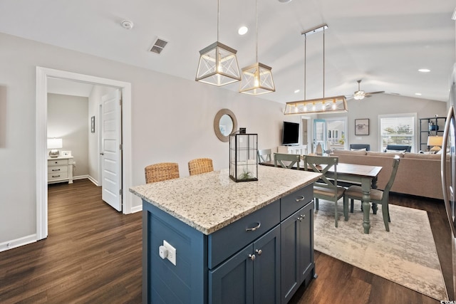 kitchen with visible vents, open floor plan, vaulted ceiling, a center island, and pendant lighting