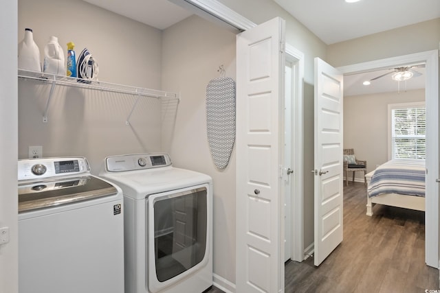 clothes washing area featuring laundry area, baseboards, wood finished floors, washing machine and clothes dryer, and recessed lighting