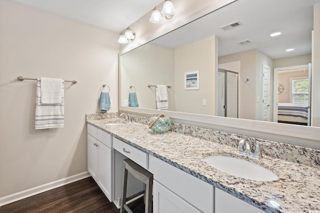 bathroom with wood finished floors, a sink, visible vents, and baseboards