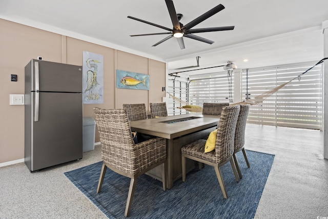 dining area featuring baseboards, light speckled floor, and a ceiling fan