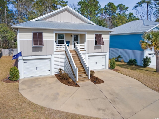 view of front of home featuring stairs, board and batten siding, covered porch, and an attached garage