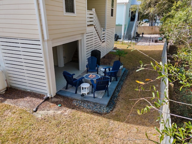 view of yard with a fire pit, a patio, stairway, and fence