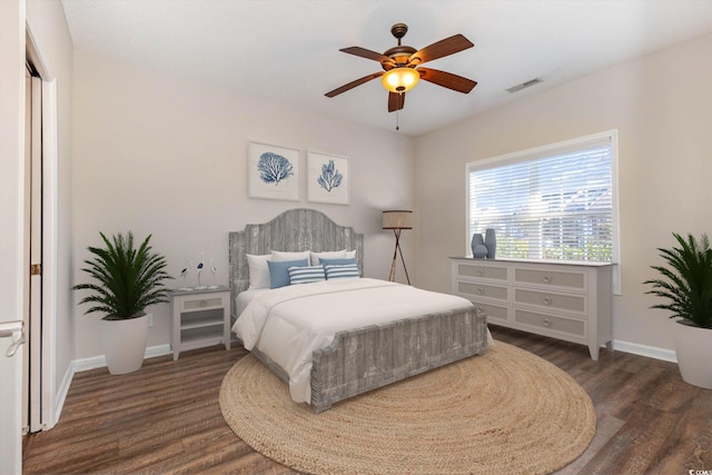 bedroom featuring a ceiling fan, dark wood finished floors, visible vents, and baseboards