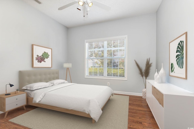 bedroom with ceiling fan, baseboards, and dark wood-style flooring