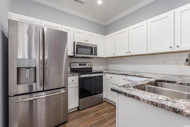 kitchen featuring white cabinets, appliances with stainless steel finishes, light stone countertops, crown molding, and a sink