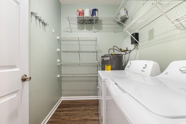 laundry room featuring laundry area, dark wood-style flooring, baseboards, water heater, and independent washer and dryer