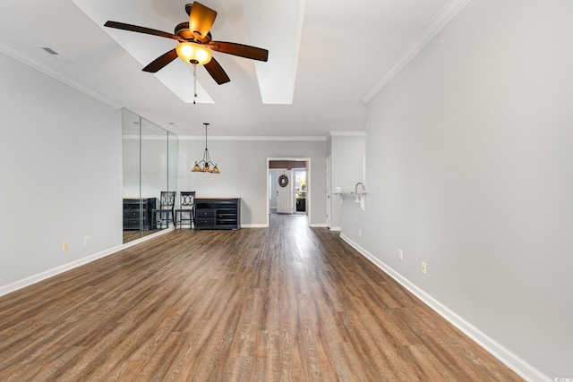 unfurnished living room with ceiling fan, wood finished floors, visible vents, baseboards, and ornamental molding