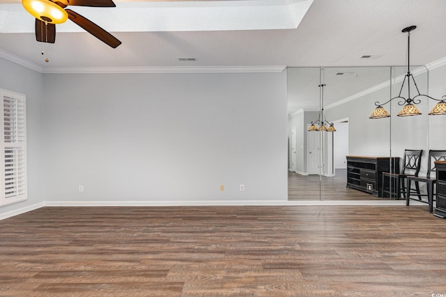 unfurnished living room with ornamental molding, visible vents, baseboards, and wood finished floors