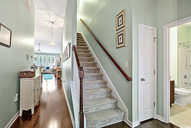 staircase with hardwood / wood-style flooring, visible vents, and baseboards