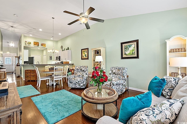 living area featuring baseboards, high vaulted ceiling, recessed lighting, hardwood / wood-style flooring, and ceiling fan with notable chandelier