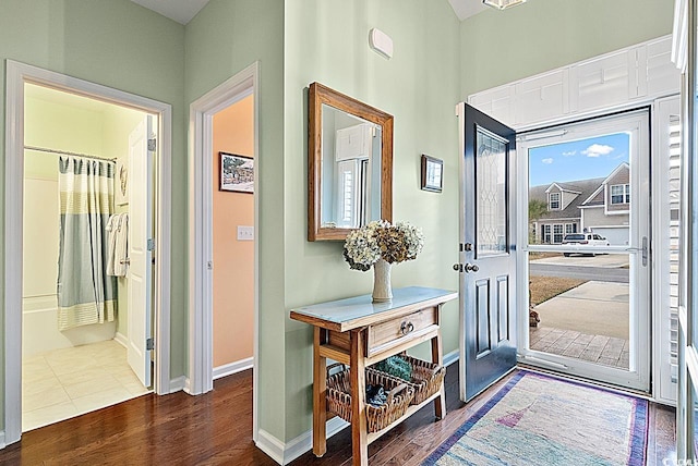 entrance foyer with dark wood-type flooring and baseboards