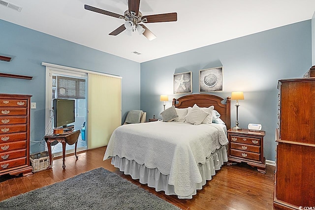 bedroom featuring a ceiling fan, access to outside, wood finished floors, and visible vents