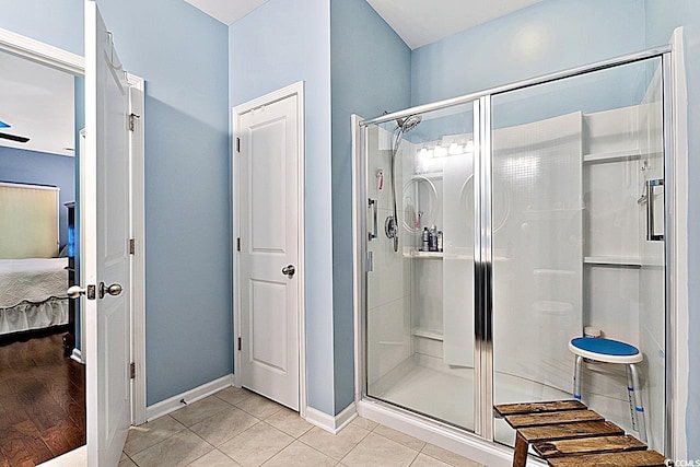 ensuite bathroom with ensuite bath, baseboards, a stall shower, and tile patterned floors