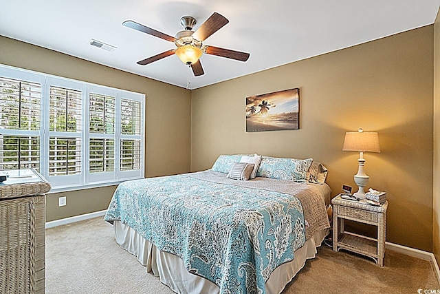 carpeted bedroom with visible vents, baseboards, and a ceiling fan