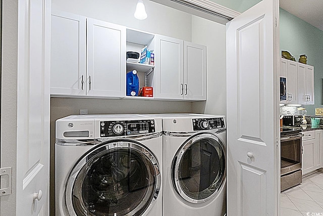 clothes washing area featuring cabinet space and washing machine and dryer