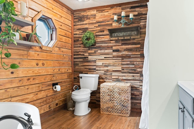 bathroom with toilet, vanity, wood-type flooring, and a textured ceiling