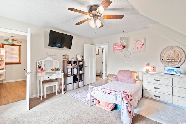 carpeted bedroom with ceiling fan and a textured ceiling