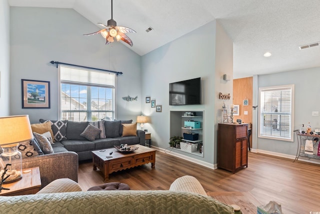 living room featuring dark wood-style floors, visible vents, and baseboards