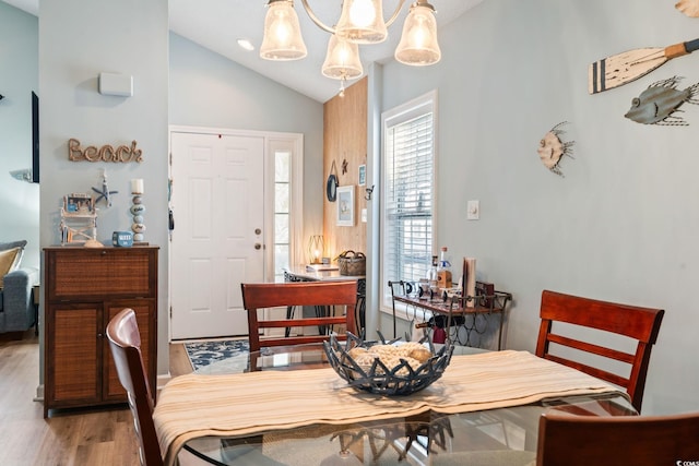 dining space featuring light wood-style floors and vaulted ceiling