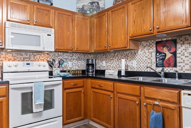 kitchen with white appliances, a sink, decorative backsplash, brown cabinetry, and dark countertops