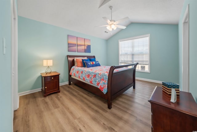 bedroom featuring lofted ceiling, wood finished floors, and baseboards