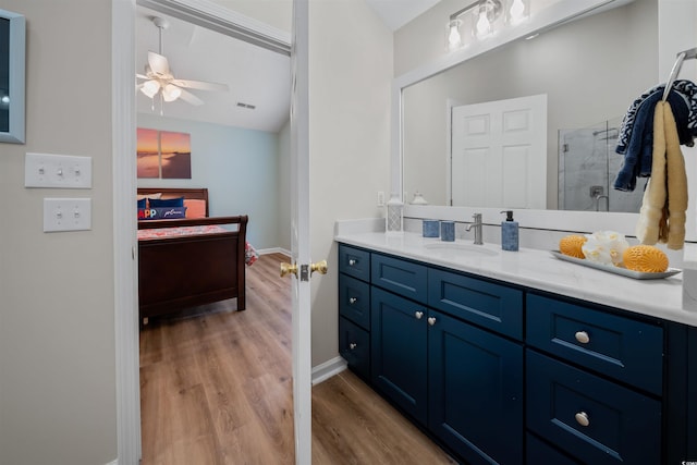 bathroom featuring a stall shower, a ceiling fan, lofted ceiling, wood finished floors, and vanity