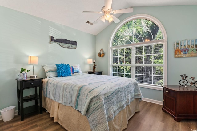 bedroom with lofted ceiling, visible vents, baseboards, and wood finished floors