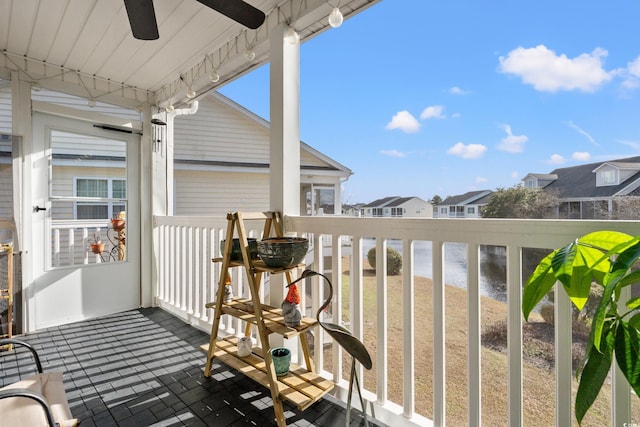 balcony featuring a water view and a ceiling fan