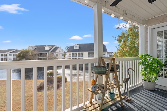 balcony featuring a ceiling fan, a residential view, and a water view