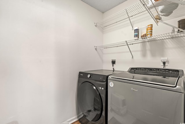 laundry room featuring laundry area, washer and clothes dryer, and baseboards