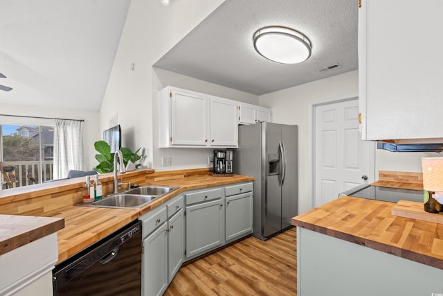 kitchen with black dishwasher, visible vents, a sink, wood counters, and stainless steel fridge with ice dispenser