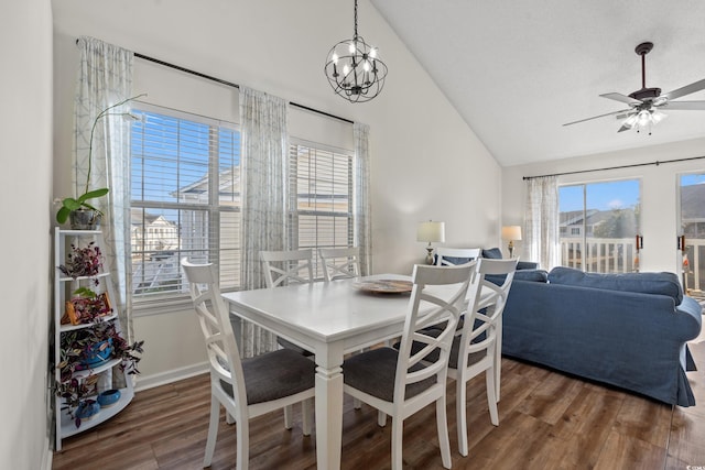 dining area with dark wood-type flooring, lofted ceiling, baseboards, and ceiling fan with notable chandelier