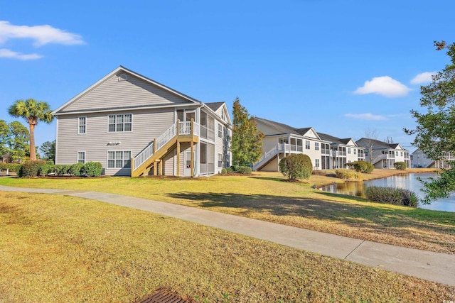 view of property exterior featuring stairs, a lawn, and a residential view